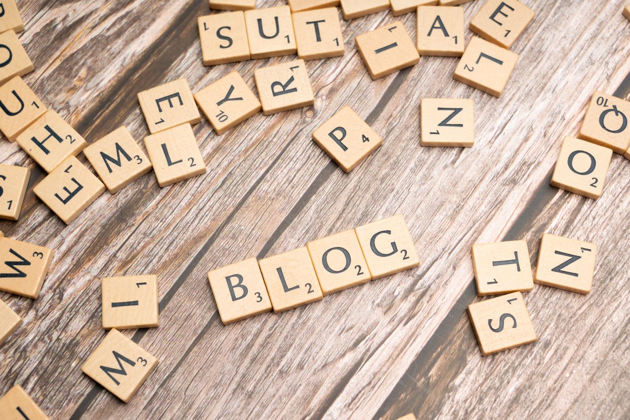 Welcome to Negative Marketing Scattered wooden letter tiles spelling 'Blog' on a rustic wood background.