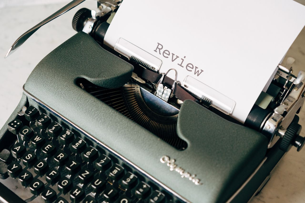 Welcome to Negative Marketing Classic green typewriter with paper displaying 'Review', perfect for creative writing themes.